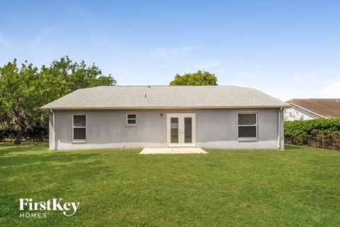 a small gray house with a grassy yard