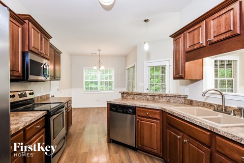 A kitchen with wooden cabinets and a stainless steel dishwasher.