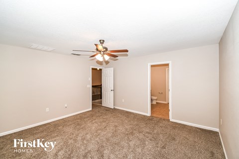 a living room with carpet and a ceiling fan