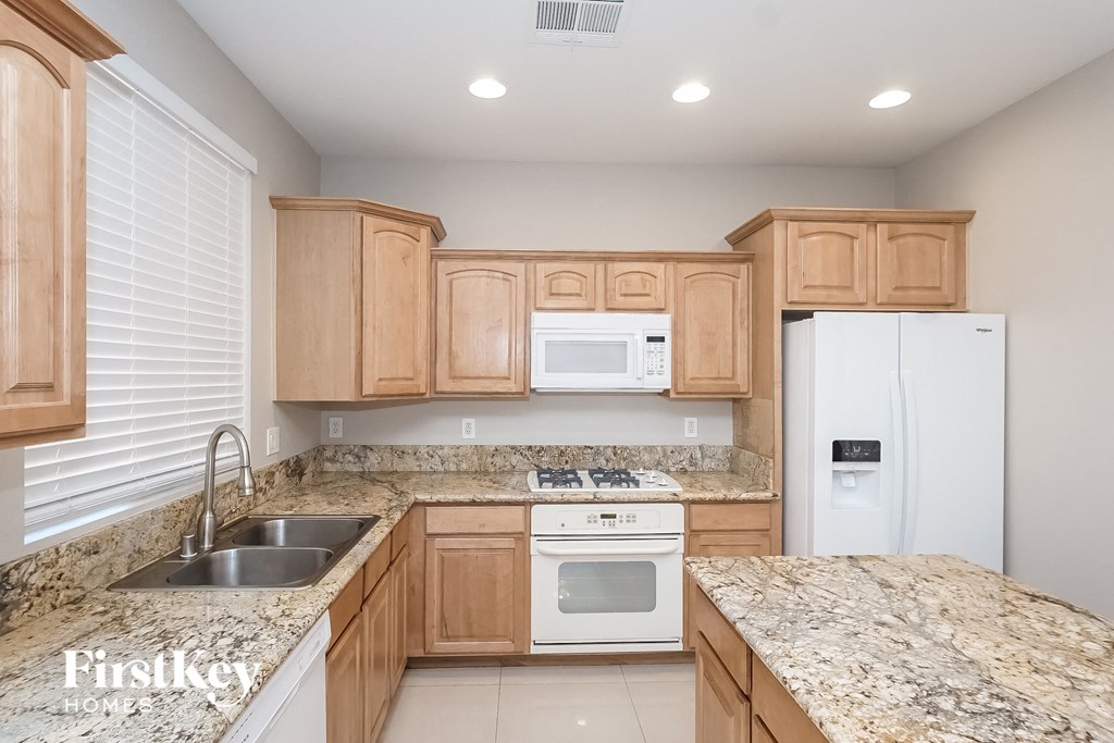 A kitchen with wooden cabinets and granite countertops.