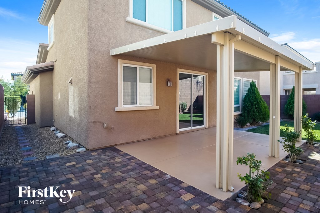 A house with a patio and a brick walkway in front.