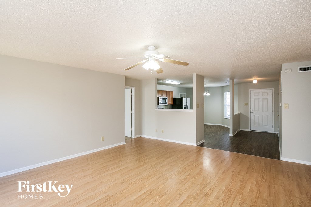 A room with wooden floors and a ceiling fan.