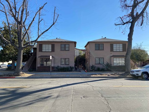 a street view of an apartment building with a car parked in front