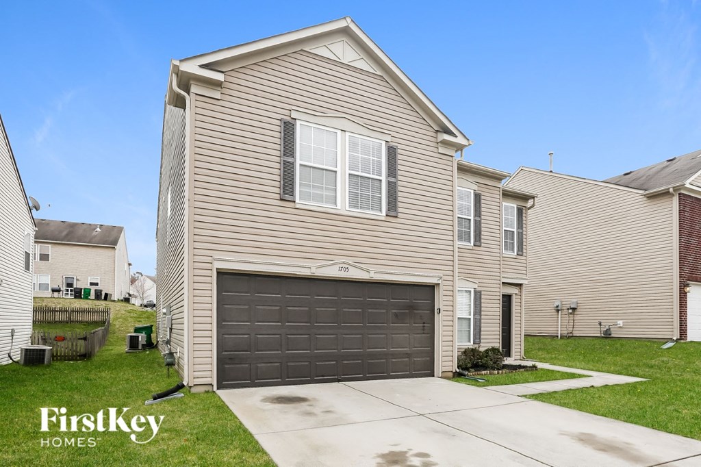 a tan house with a black garage door