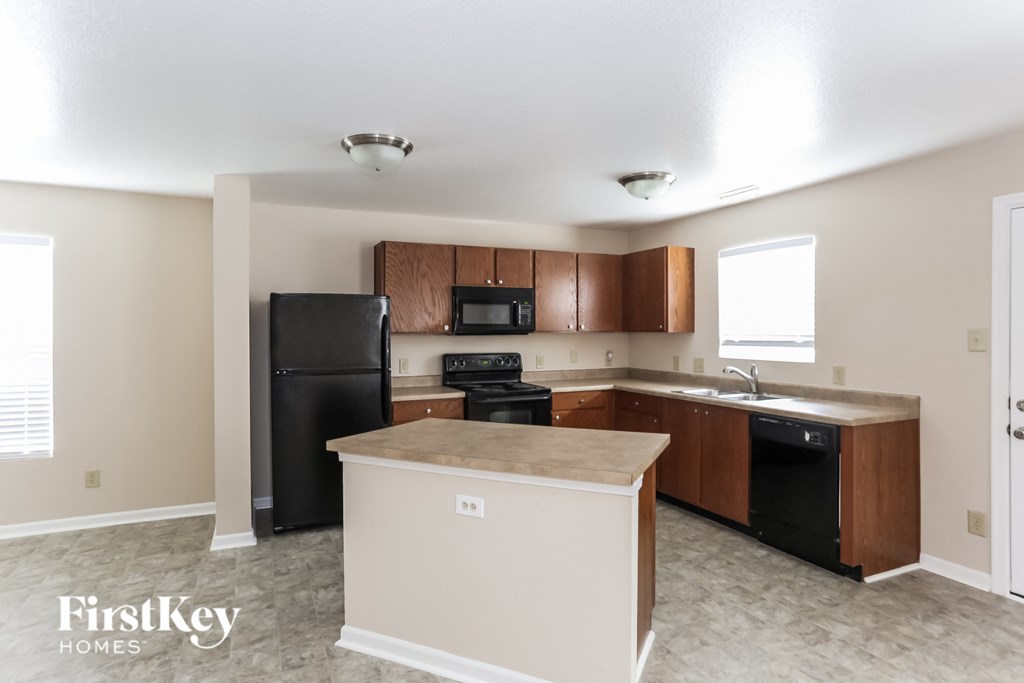 a kitchen with a counter top and a black refrigerator
