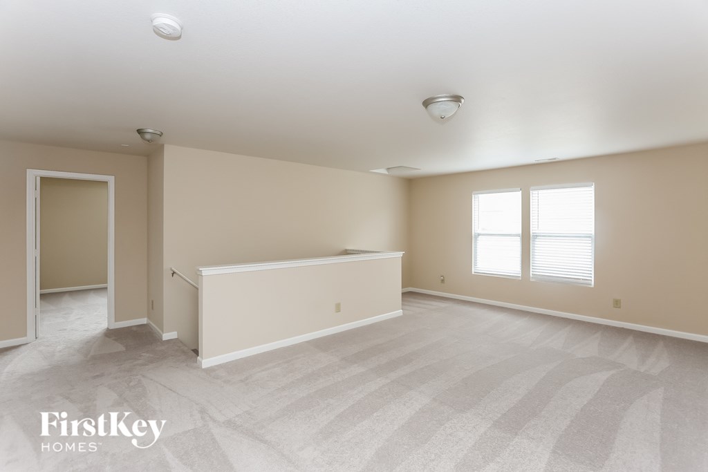 the living room and dining room of an empty house with a counter and two windows
