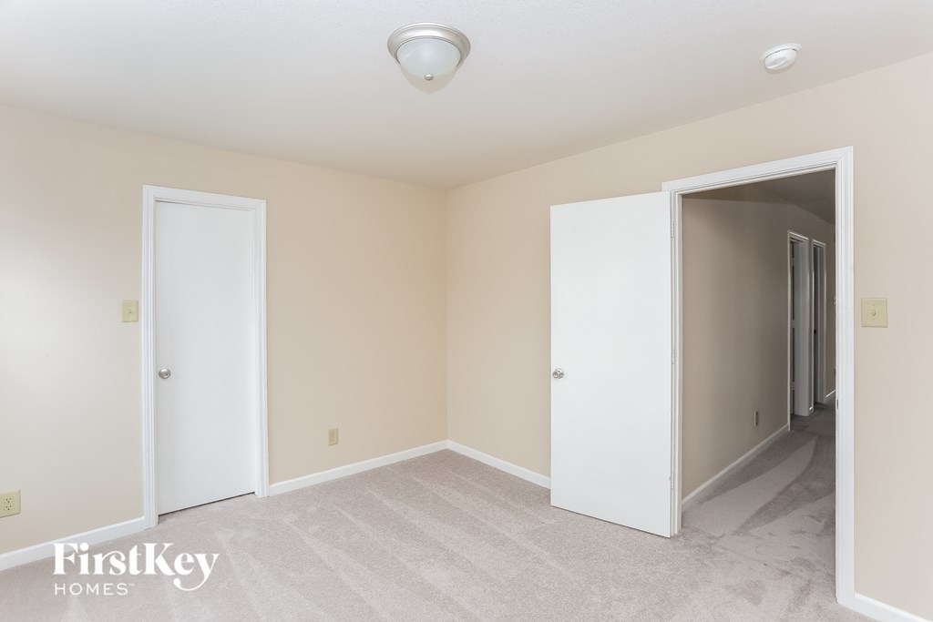a bedroom with two closets and a door to a hallway