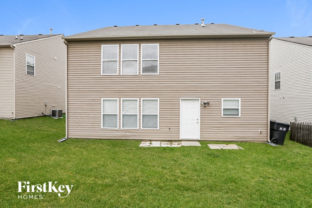 the backyard of a house with a yard and a white door