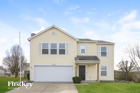 a yellow house with a white garage door