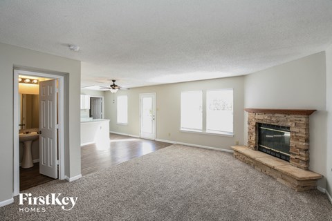 a living room with a fireplace and a carpeted floor