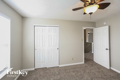 a bedroom with two closets and a ceiling fan
