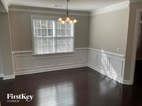 a dining room with white wainscoting and a window