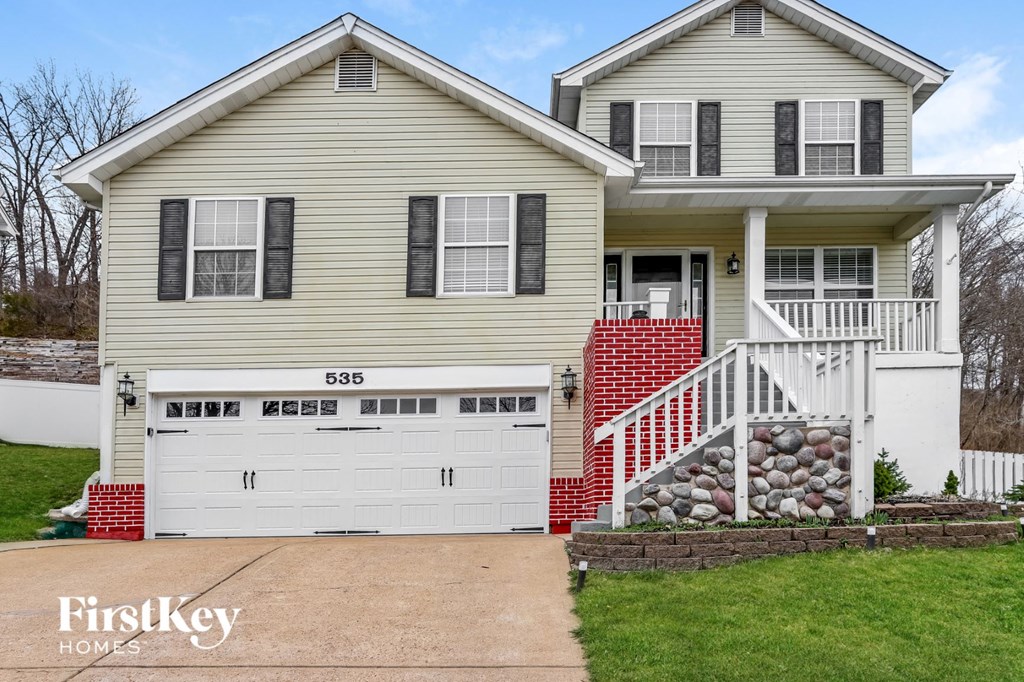 A two-story house with a garage and a front porch.