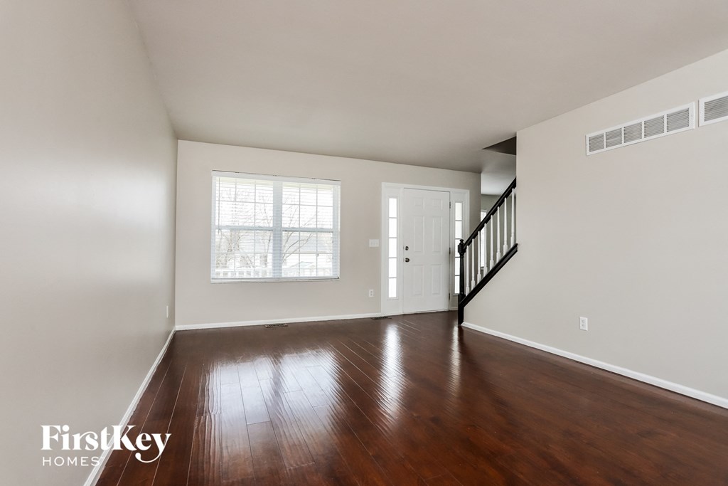 A room with wooden floors and a staircase.