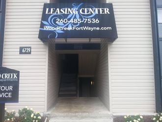 the front entrance of a building with a leasing center sign
