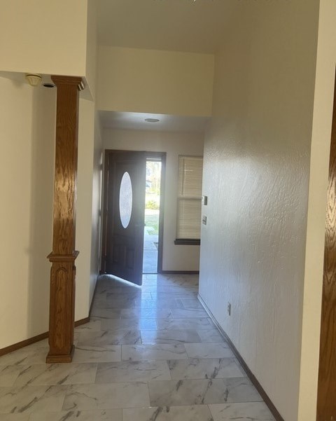 an empty hallway with a door to a room and a tile floor
