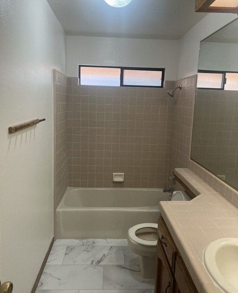 a bathroom with a toilet and a tub and a sink