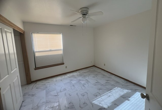 a empty room with a ceiling fan and a window