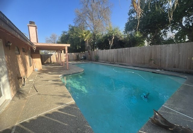 a swimming pool in a backyard next to a fence