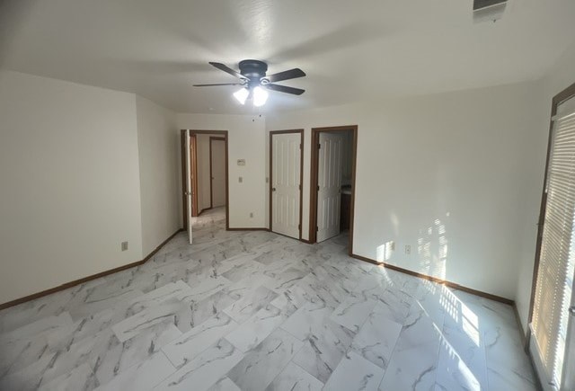a living room with a ceiling fan and a marble floor