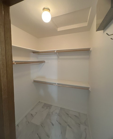 a walk in closet with a shelf and a light