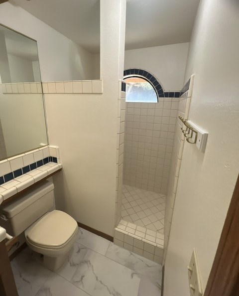 a white bathroom with a toilet and a shower