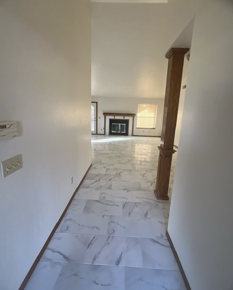 an empty living room with marble flooring and a fireplace