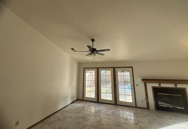 a empty living room with a ceiling fan and a fireplace