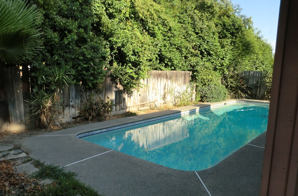the pool is in the backyard of the house
