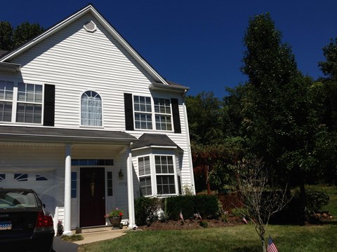 a white house with black shutters and a blue sky