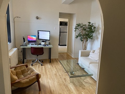 a living room with a couch and a desk with a computer