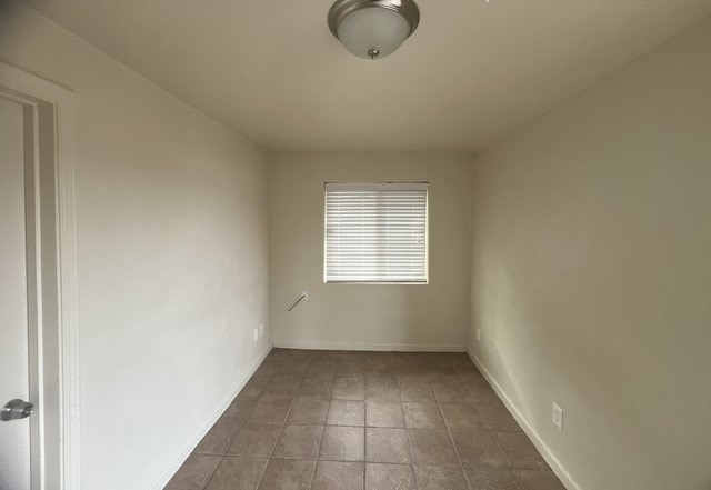 a empty room with a window and tiled floors