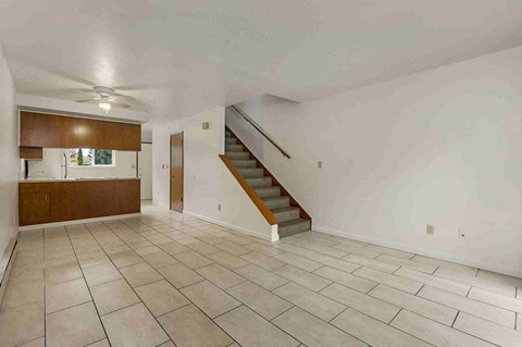 a living room with a staircase and a tiled floor