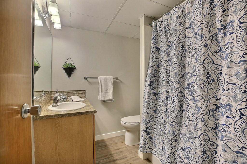 a bathroom with a blue and white shower curtain and a toilet