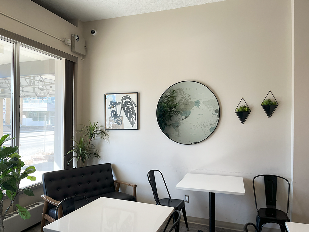 a dining room with tables and chairs and a round mirror on the wall