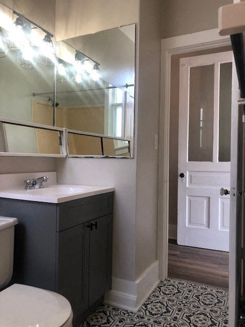 a bathroom with a sink toilet and a mirror