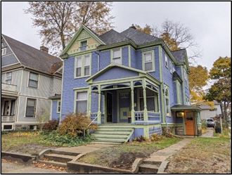 a blue house with a porch and stairs