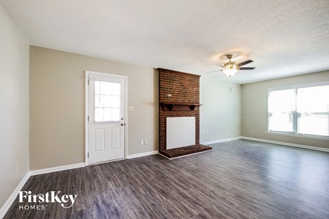 A room with a fireplace and a ceiling fan.