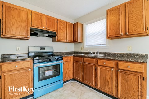 a kitchen with wooden cabinets and a blue stove and oven