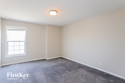 the living room of a home with a concrete floor and a window