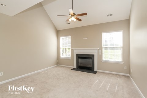 a living room with a fireplace and a ceiling fan