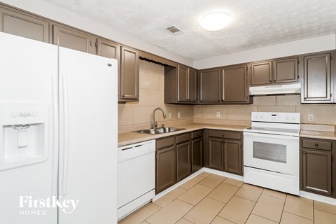 A kitchen with brown cabinets and a white fridge.