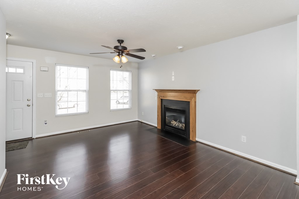 a living room with a fireplace and a ceiling fan