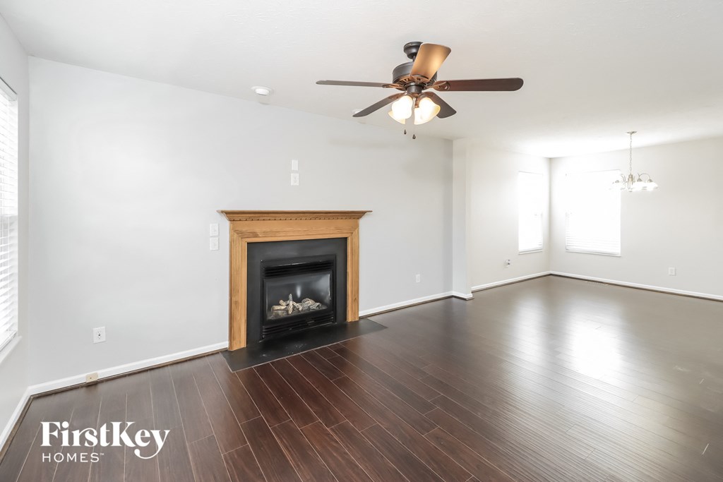 the living room with wood flooring and a fireplace