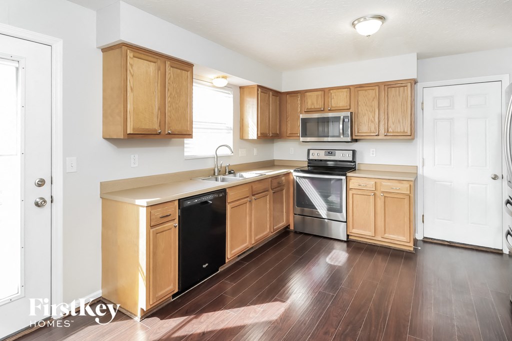 a kitchen with wood flooring and wooden cabinets