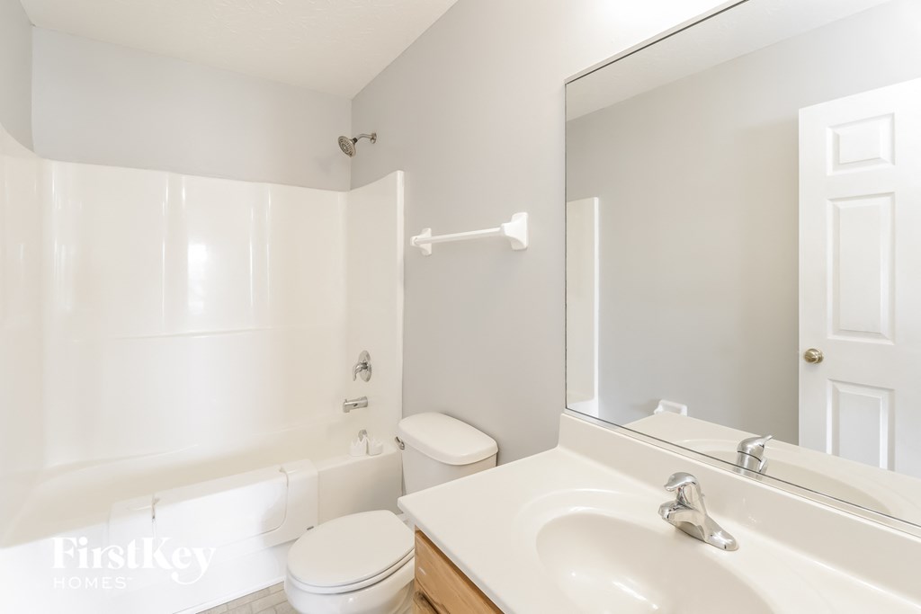 a bathroom with a sink toilet and a mirror