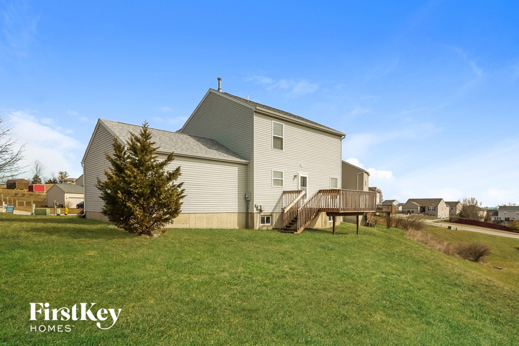 the view of the house from the backyard with the deck