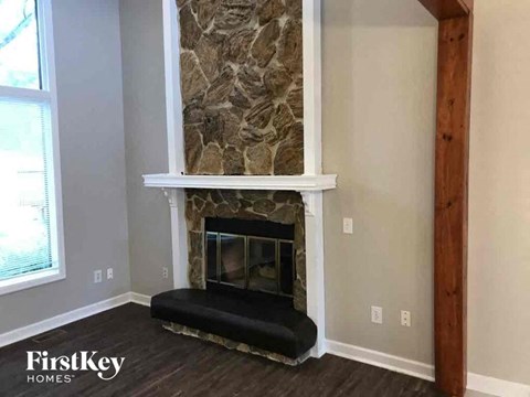 a stone fireplace in a living room with a wood floor