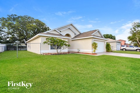 a white house with a yard and a fence