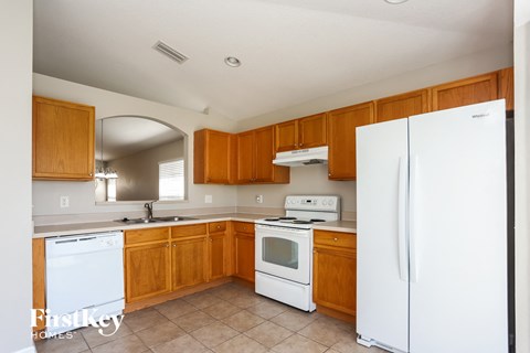 a kitchen with white appliances and wooden cabinets